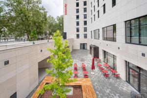 een uitzicht op een gebouw met tafels en stoelen bij IntercityHotel Karlsruhe in Karlsruhe