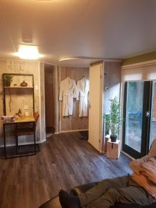 uma sala de estar com roupas brancas penduradas numa parede em H15, Sauna- en Wellnesschalet geschikt voor 2 personen em Epe