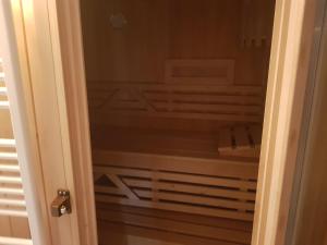 uma porta para um armário com uma cama dentro em H15, Sauna- en Wellnesschalet geschikt voor 2 personen em Epe