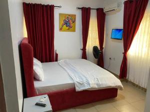 a bedroom with a bed with red curtains at Christmas Promo-Time in Wupa