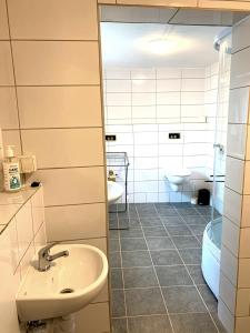 een badkamer met een wastafel, een toilet en een bad bij Haus Linde in Biesenthal