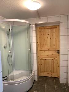 een badkamer met een douche en een houten deur bij Haus Linde in Biesenthal