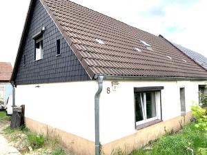 a white house with a black roof at Monteur-Haus Linde in Biesenthal