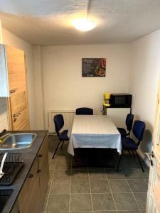 een keuken met een tafel en stoelen en een wastafel bij Haus Linde in Biesenthal