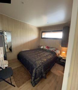 a bedroom with a bed with a black bedspread at EcoKub T3 Indépendant Proche plages et lac in Soustons +16 photos