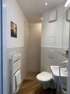 a white bathroom with a toilet and a sink at Versava Apartments in Vienna