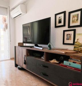 a living room with a flat screen tv on a entertainment center at Casa Marino in Benicàssim