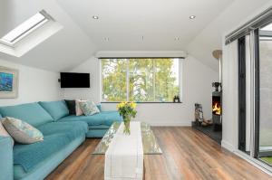 a living room with a blue couch and a table at Moon's Cottage in Fowey