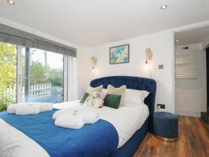 a bedroom with a blue and white bed and a window at Moon's Cottage in Fowey