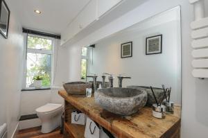 ein Badezimmer mit zwei Waschbecken auf einer Holzplatte in der Unterkunft Moon's Cottage in Fowey + 39 Fotos