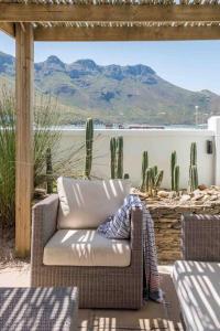 una silla en un patio con cactus y vistas en Avisa Villa - 4 bedroom Villa with Majestic Ocean Views en Ciudad del Cabo