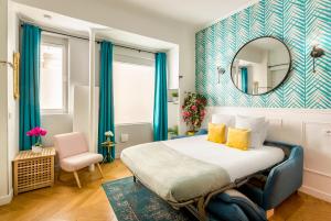 パリにあるCocoon Loft - Champs-Elyséesのベッドと鏡が備わるホテルルーム