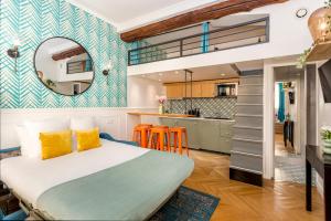 a bedroom with a large bed and a kitchen at Cocoon Loft - Champs-Elysées in Paris