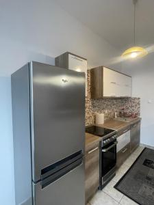 una cucina con frigorifero in acciaio inossidabile di Palank Apartman a Mosonmagyaróvár