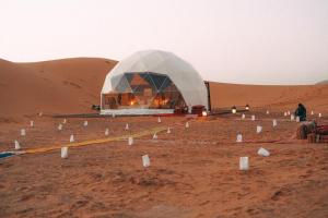 ein Zelt in der Wüste mit einem Feuer darin in der Unterkunft Golden Desert Camp in Al Wāşil