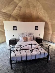 a bedroom with a bed with two night stands at Golden Desert Camp in Al Wāşil