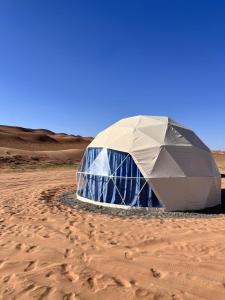 a dome tent in the middle of the desert at Golden Desert Camp in Al Wāşil