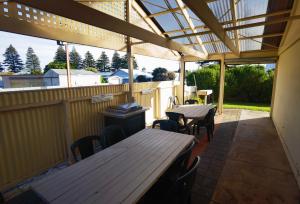 een terras met tafels en stoelen en een luifel bij Beachport Motor Inn in Beachport