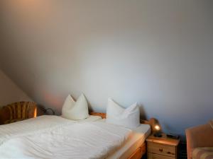 two beds with white pillows sitting next to each other at Bernstein-Fewos ca 15 Gehminuten zum Ostseestrand in Zempin +9 photos