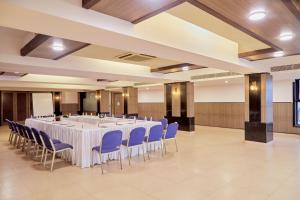 duża sala bankietowa z białymi stołami i niebieskimi krzesłami w obiekcie Hotel Orion Centrally near North Goa & Panjim w mieście Porvorim