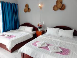 a bedroom with two beds with towels on them at Kampot Nature Villa Resort in Kampot