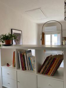 ein weißes Regal mit Büchern und einem Spiegel in der Unterkunft La Casa della Torre in Pisa