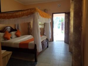 a bedroom with a bed with a canopy at Allamanda Gardens Resort in Nakuru
