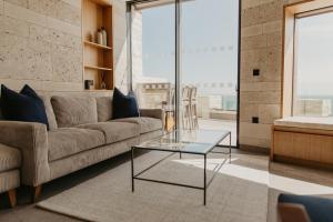 a living room with a couch and a glass table at Clifftops Lodge in Portland