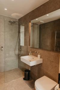 a bathroom with a sink and a shower and a toilet at Clifftops Lodge in Portland