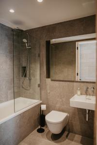 a bathroom with a tub and a toilet and a sink at Clifftops Lodge in Portland