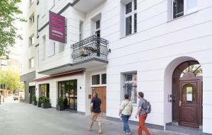 three people walking outside of a building at Safestay Berlin Kurfurstendamm in Berlin