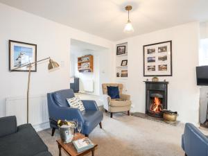 a living room with a fireplace and blue chairs at Silva in Penmon