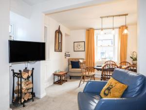 a living room with a blue couch and a tv at Silva in Penmon