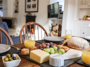 a table with cheese and bread and glasses of orange juice at Silva in Penmon
