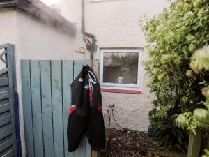 a surfboard hanging on the side of a fence at Silva in Penmon