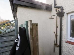 a building with a door and a shower on the side at Silva in Penmon
