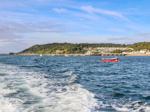a red boat in the middle of a body of water at Silva in Penmon