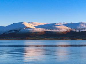 a large body of water with a mountain in the background at Silva in Penmon