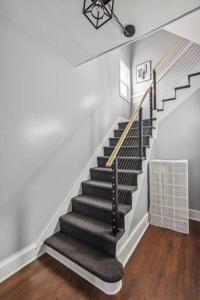 - un escalier dans une maison dotée de murs blancs et de parquet dans l'établissement Large 4-Br home / 15 min to NYC, à Mount Vernon