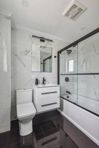La salle de bains est pourvue de toilettes et d'une douche en verre. dans l'établissement Large 4-Br home / 15 min to NYC, à Mount Vernon