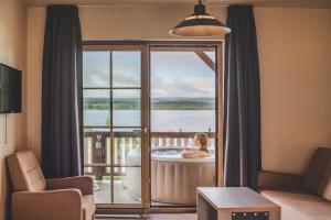 a woman in a bath tub in a room with a view at Hotel Resort Relax in Dolní Vltavice