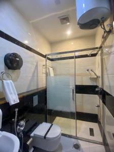 a bathroom with a glass shower and a toilet at Aral Hotel Apartments in Tabuk