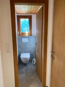 ein Bad mit einem WC und einem Fenster in der Unterkunft Idyllisch gelegene grosszügige Ferienwohnung Chumma in Frauenkirch