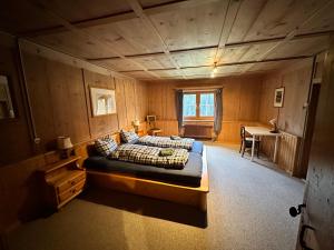 Frauenkirch的住宿－Idyllisch gelegene grosszügige Ferienwohnung Chumma，一间卧室配有一张床和一张书桌