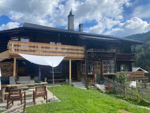 ein Haus mit einem weißen Regenschirm davor in der Unterkunft Idyllisch gelegene grosszügige Ferienwohnung Chumma in Frauenkirch