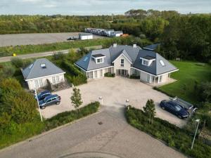 una vista aérea de una casa con un coche en la entrada en Luxe prive-kamer - studio in villa aan zee, Dishoek, vernieuwd, en Dishoek