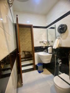 a bathroom with a white toilet and a sink at Aral Hotel Apartments in Tabuk