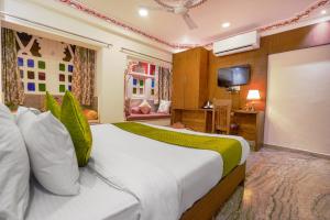 a bedroom with a large bed and a television at Royal Rafahiya Haveli - LAKE FACING in Udaipur