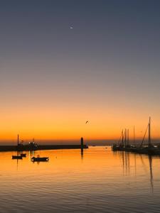 um pôr-do-sol sobre um corpo de água com barcos em Porto Antico em Bari