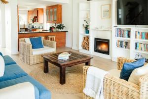 开普敦Avisa Villa - 4 bedroom Villa with Majestic Ocean Views的带咖啡桌和壁炉的客厅